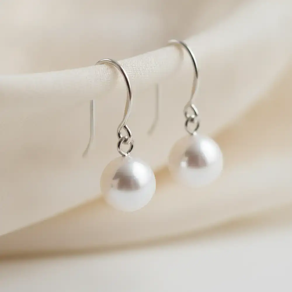Close up of minimalist pearl drop earrings